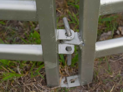 A pin is connecting two cattle corral fence.