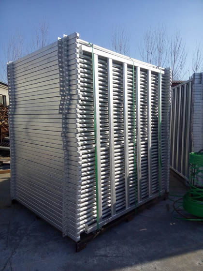Several pieces of horse corral panels are packed by the wooden pallet.
